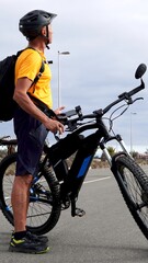 Fototapeta premium Active man cycling an electric mountain bike, dressed in sportswear and helmet, enjoying a healthy lifestyle and outdoor activity under a spring sky in the Canary Islands