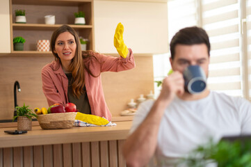Woman arguing with man avoiding doing chores