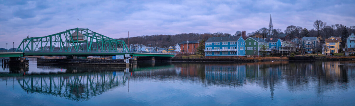 A New England winter landscape with the landmark Grand Avenue Swing Bridge and historic houses and church on the forest hill above the Quinipiac River in Fair Haven, New Haven County, Connecticut