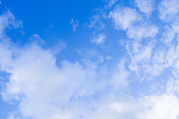 Beautiful bright blue sky with light airy white clouds.
