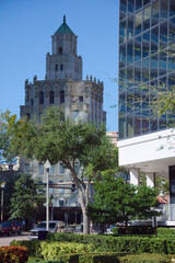 Architectural Contrast: Historic Snell Arcade Tower With Ornate Details Beside Modern Glass Building in City Center in St. Petersburg, FL. Urban scene featuring a historic, ornate tower adjacent to a 