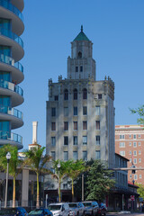 Architectural Contrast: Historic Snell Arcade Tower With Ornate Details Beside Modern Glass Building in City Center in St. Petersburg, FL. Urban scene featuring a historic, ornate tower adjacent to a 