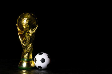 Obraz premium Moscow, Russia - December 13, 2025: FIFA World Cup Trophy with small soccer ball against black background. Free space for your text