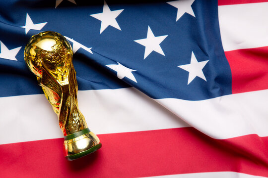 Moscow, Russia - December 13, 2025: FIFA World Cup Trophy on the Unites States of America national Flag. USA is the FIFA World Cup 2026 host country with Mexico and Canada