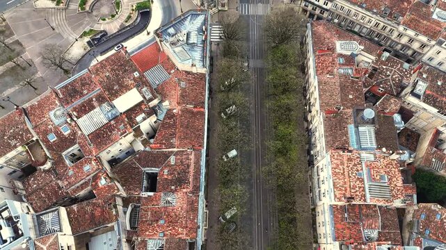 Top down drone shot of Bordeaux roundabout with tram tracks and stone buildings forming geometric pattern in morning