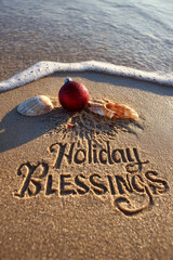 Holiday Blessings Carved into Damp Sand with Golden Sun Over Ocean, Ornament Decor and Approaching Tide Foam &ndash; ideal for festive greeting cards