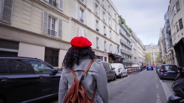 Smiling African millennial woman holding hands and leading the way on a Paris street, Eiffel Tower in the background. Wide-angle travel portrait with lively city vibe and warm sunlight.