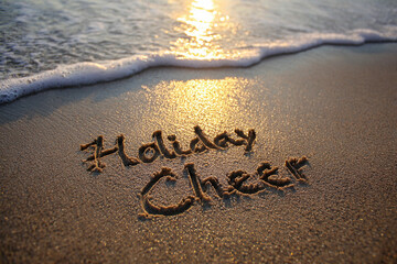 Holiday Cheer Hand-Drawn into Wet Sand with Golden Hour Glow, Advancing Ocean Wave and Low Glowing Sun &ndash; good for banner design