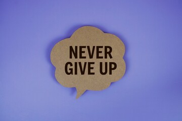 Never Give Up text with speech bubble top view on purple background