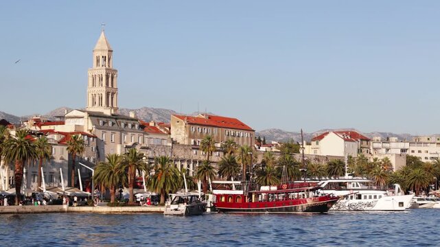 Largest port in Adriatic coast is located in Split. Private boats and yachts sway on waves, pedestrian tourists walk along embankment