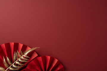 A rich red background features folded paper rosettes and a gold fern accent, evoking festive Chinese New Year mood and inviting warm greetings across cultures