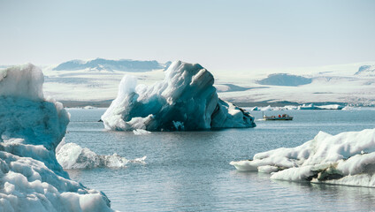 Majestic blue icebergs floating in Jokulsarlon Glacier Lagoon, Iceland, with snow-covered mountains in the background