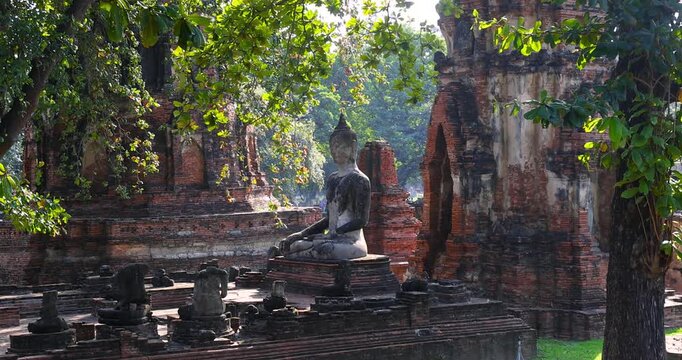 Buddha statue and ruins at historic Wat Mahathat means Temple of the Great Relic, in Ayutthaya, Thailand.