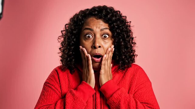 Woman Reacts With Shock and Surprise Against a Pink Background.