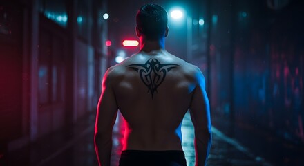 Muscular Man with Tribal Tattoo Standing in Neon lit Urban Alley