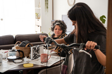 A woman is sitting at a table with a mug and a bicycle