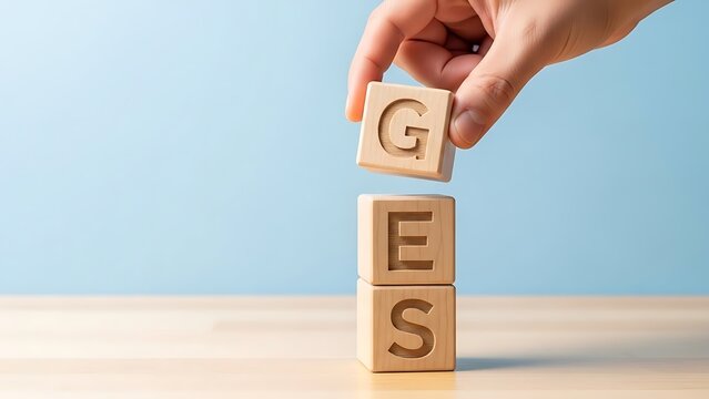 Stacking Wooden Blocks Spelling GES with Hand Placing G Block.