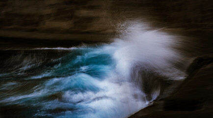 Long exposure abstract water flow crashing into dark rock canyon blue current and white spray slow shutter fine art nature photography capturing raw energy calm meditation motion and time at dusk