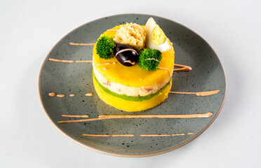 PERUVIAN FOOD. Causa rellena de pollo. Chicken causa rellena. Traditional peruvian dish from yellow potato, chicken, avocado on white plate.