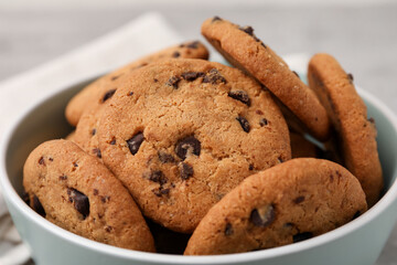 Delicious chocolate chip cookies in bowl on table, closeup
