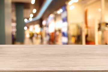 Empty wooden table against blurred view of shopping mall. Space for design