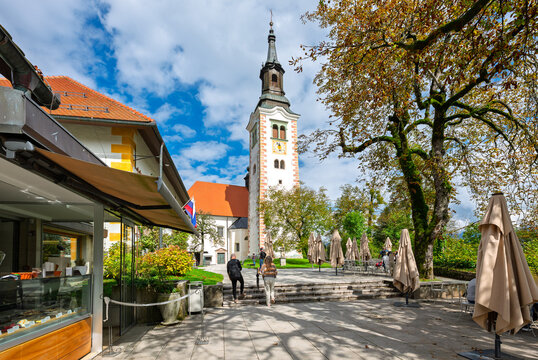 Cafes and shops in a small park space under the Church of the Assumption of Mary on Bled Island, on the lake at Bled Slovenia.