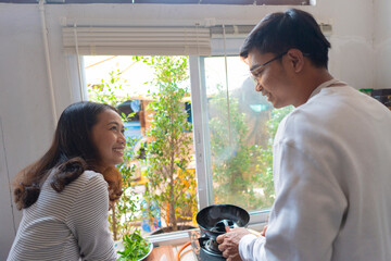 The couple is cooking together in the kitchen.