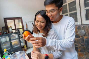 The couple is cooking together in the kitchen.
