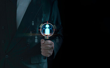 Target audience and customer profiling concept shown by a business professional using a magnifying glass to identify key users in a digital analytics environment for strategic decision-making.