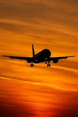 Fototapeta premium Airplane landing at sunset with a clear sky and warm evening light