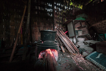 A glimpse into a traditional, dimly lit rural kitchen, where a pot simmers over a rustic wood fire, embodying a simple, time-honored way of living