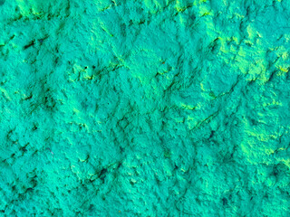 green paint background. Texture of natural stone for wall. Closeup. isolated macro texture coastal cliffs in sunlight. Green wall stone texture