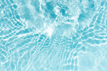 Blue water with ripples on the surface. Defocus blurred transparent blue colored clear calm water surface texture with splashes and bubbles. Water waves with shining pattern texture background.