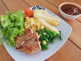 Grilled Chicken Steak with Boiled Potatoes and Mixed Vegetables on Wooden Table