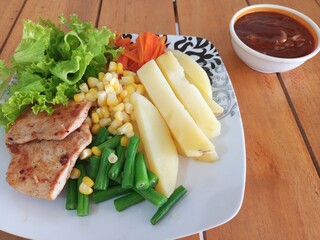 Grilled Chicken Steak with Boiled Potatoes and Mixed Vegetables on Wooden Table