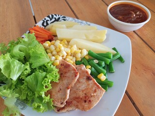 Grilled Chicken Steak with Boiled Potatoes and Mixed Vegetables on Wooden Table
