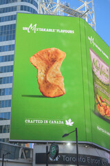 Fototapeta premium electronic sign featuring advertisement for Miss Vickie’s Spicy Dill Pickle, a Canadian kettle-cooked potato chip brand (PepsiCo) near Sankofa Square, Toronto