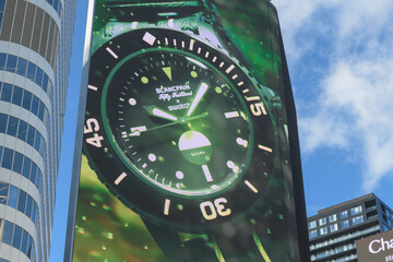 Naklejka premium close-up of digital advertisement featuring Swatch x Blancpain collaboration (Blancpain’s iconic Fifty Fathoms) dive watch facing Sankofa Square, Toronto