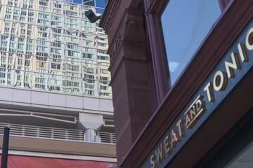 Naklejka premium defocused sign of Sweat and Tonic, a fitness center, located at 225 Yonge St, The Ryrie Building, Toronto (contrast of architecture styles)