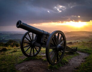 Cannon on a hilltop overlooking a landscape at sunset