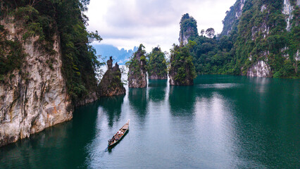 Majestic limestone cliffs tower over the tranquil waters of Cheow Lan Lake in Khao Sok Thailand
