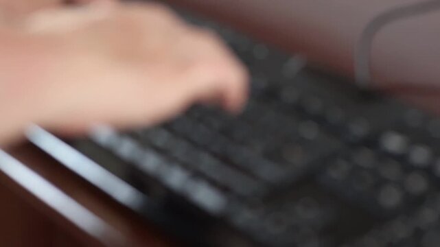 Un primer plano de las manos de una mujer adulta en movimiento en un teclado de una computadora con un poco de desenfoque