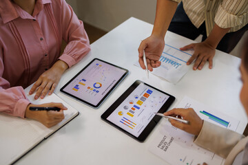 Marketing agency diverse workers analyzing research results, paper reports with diagrams on meeting table, discussing business startup creative strategy, planning finance, expenses, profit

