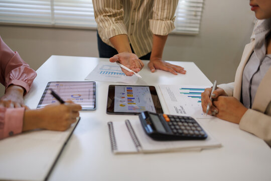 Marketing agency diverse workers analyzing research results, paper reports with diagrams on meeting table, discussing business startup creative strategy, planning finance, expenses, profit

 - Powered by Adobe