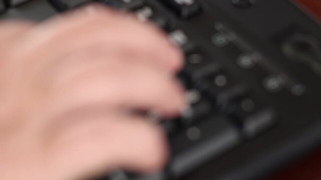 Un primer plano de las manos de una mujer adulta en movimiento en un teclado de una computadora con un poco de desenfoque