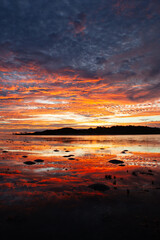 An beautifully vibrant reflective orange sunrise over Red Island, situated off the shores of Seisia, on the Cape York Peninsula, QLD.