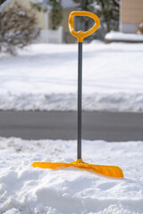 shovel in snow in front of residential house