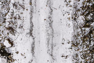 Snowy Dirt Road With Tire Tracks and Rocky Terrain in British Columbia, Canada