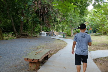 Man Walking Towards Tents Along a Winding Path at Campsite