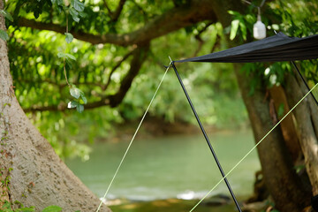 Camping Tarp Awning Detail Over Stream in Lush Green Forest